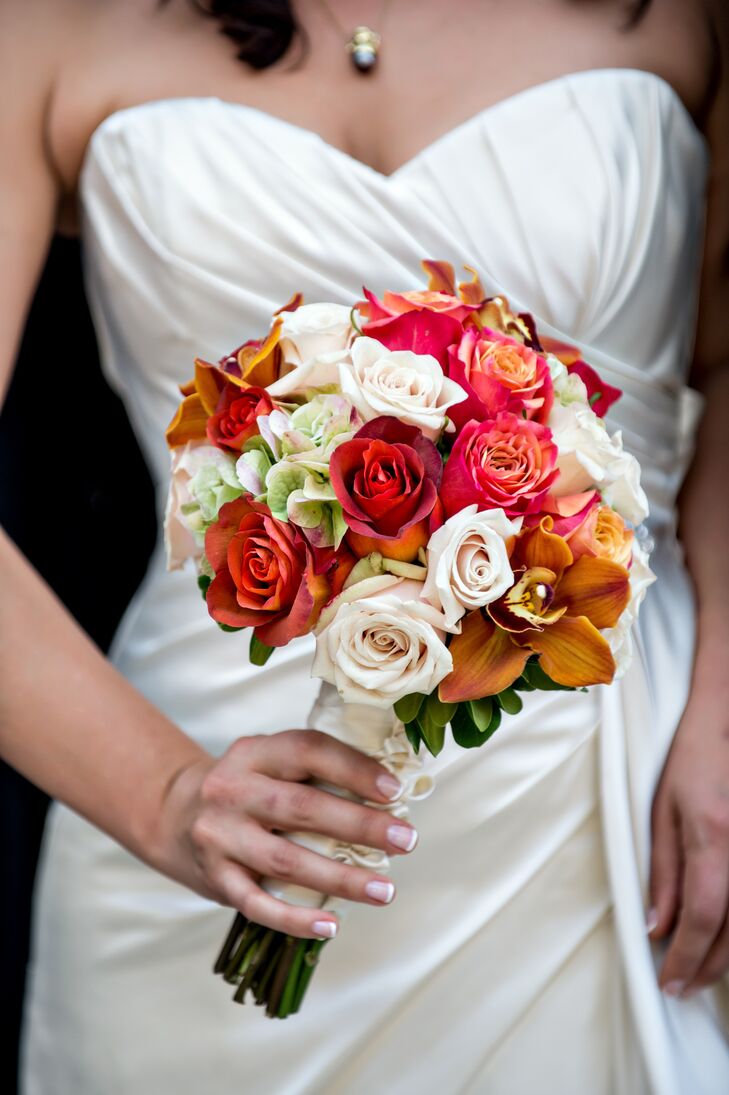 Rose held a red, burnt orange and ivory colorful bouquet made up of roses and lilies.