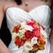 Rose held a red, burnt orange and ivory colorful bouquet made up of roses and lilies.