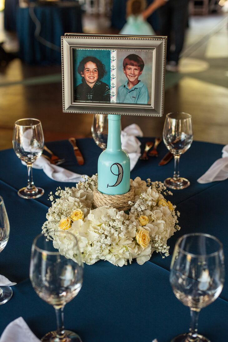 Centerpieces on the navy dining tables were simple, with flower arrangements of hydrangeas, roses and baby's breath circling blue bottles with the table numbers written on them. The bottles were wrapped in rope to tie in with the nautical theme, and they featured framed photos of Meagan and Rich as children.