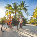 couple biking in front of palm trees in the Florida Keys