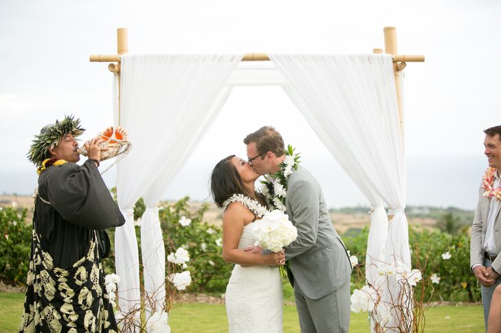 First Kiss at Draped Wedding Arch