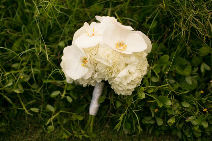 Evelyn held an ivory bouquet filled with hydrangeas and orchids, tied with a white wrap around the stems.