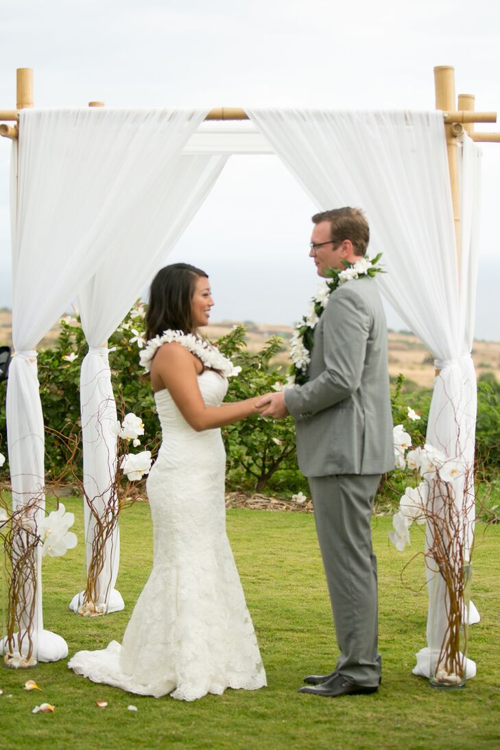 Evelyn and Neil held hands as they were married in front of the white draped wedding arch.