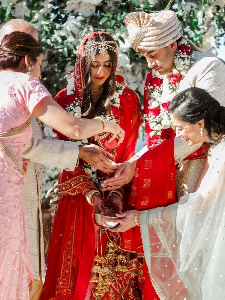 water being poured on hands of bride and groom during Hindu wedding ceremony