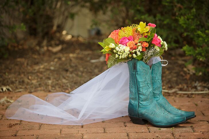 Instead of the traditional wedding heels, Heather opted for cool turquoise cowboy boots. Her bouquet consisted of bright pink and orange roses, proteas and lilies.