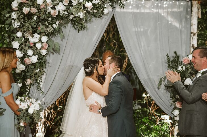 Romantic First Kiss with Greenery, Roses and Draping