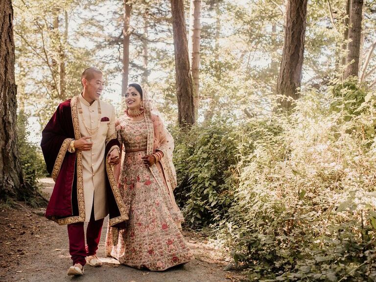 Couple holding hands smiling in forest