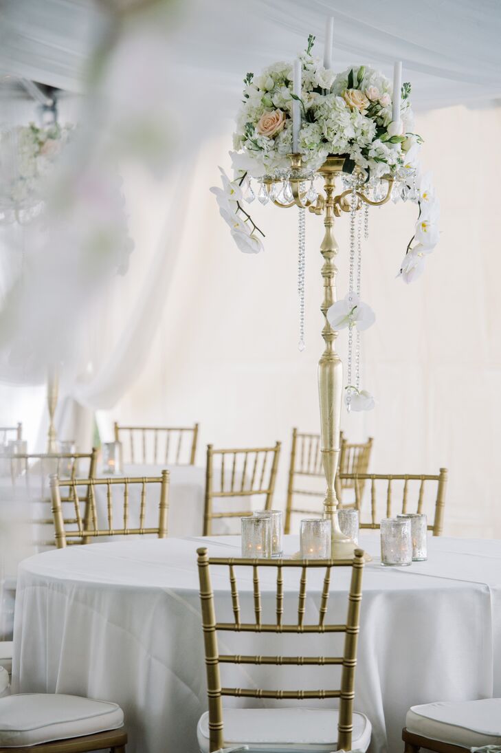 Tables were cloaked in white sequined linens and topped with glitzy candelabras and white blooms. “Our floral arrangements were over the top. I love flowers and wanted gorgeous arrangements everywhere possible—even the chandeliers were used to hold arrangements with beautiful cascading orchids,” Blakeney says.