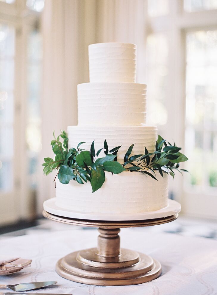 So as not to detract from the natural beauty of the surrounding gardens, the couple displayed a simple, white four-tier cake accented with greenery. It consisted of two flavors: a vanilla cake with raspberry filling and an almond cake with hazelnut filling.