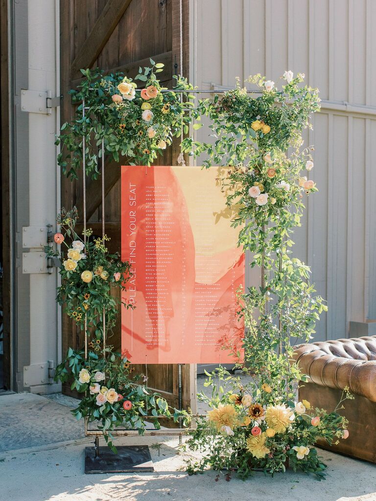 modern wedding seating chart made from marbled acrylic sign with flowers and greenery accents