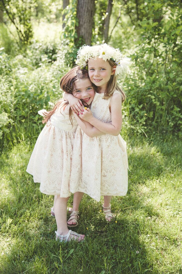While the rest of their wedding party chose completely different looks, the couple’s flower girls stood out with matching dresses. Both girls wore a champagne-colored lace dress with a high neckline and matching sash across her waist. To personalize the looks, each chose different neutral sandals and one wore a flower crown. The all-white arrangement stood out with daisies, baby’s breath, chrysanthemums, wax flowers and wildflowers all wrapped around her down hairstyle.