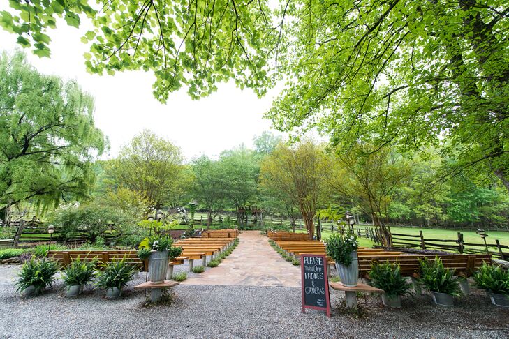 Ashley and Miguel loved the outdoor space at  Neverland Farms in the north Georgia mountains in Cleveland, Georgia, for the wedding. A stone walkway acted as the ceremony aisle with wooden benches for seating and surrounded by flourishing green trees.