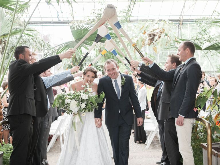 Guests holding hurley sticks to represent groom's Irish background. 