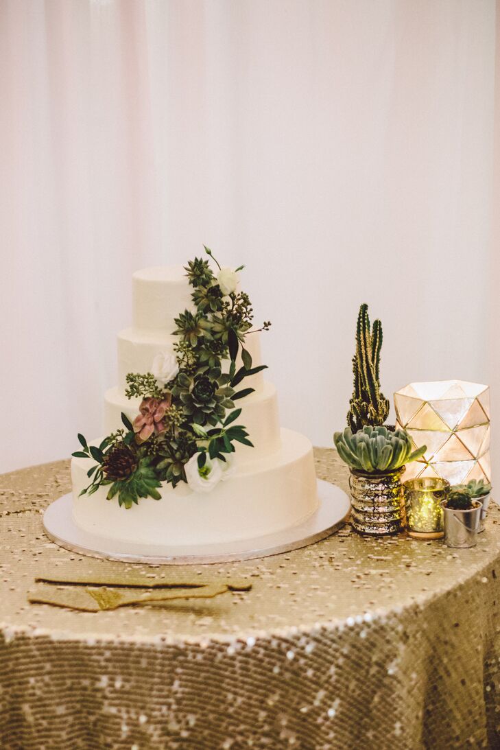 The couple chose a white wedding cake with buttercream frosting and decorated with a cascade of succulents.
