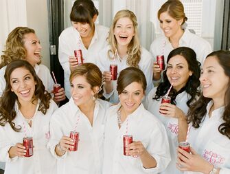 Bridesmaids drinking champagne in monogrammed getting ready shirts