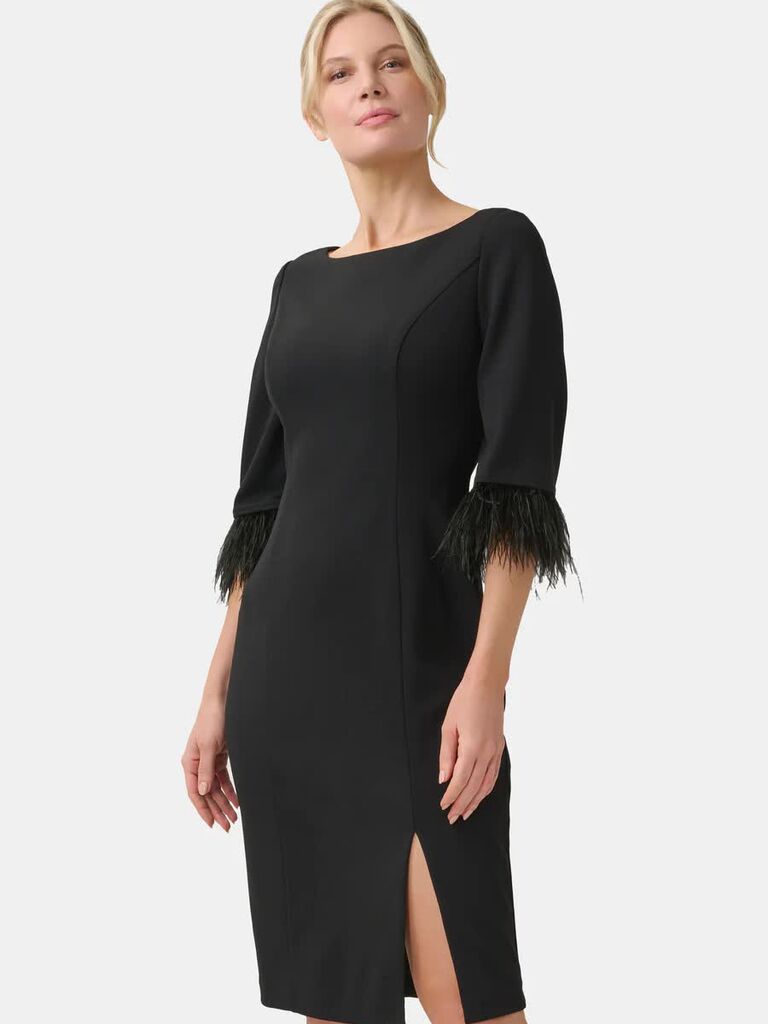 Model wearing black three-quarter dress with feather trims