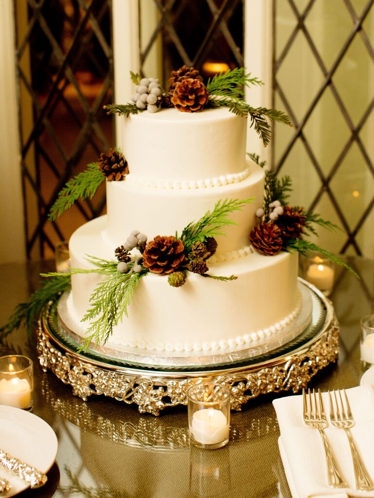 three tier winter wedding cake with white fondant, pinecones and greenry