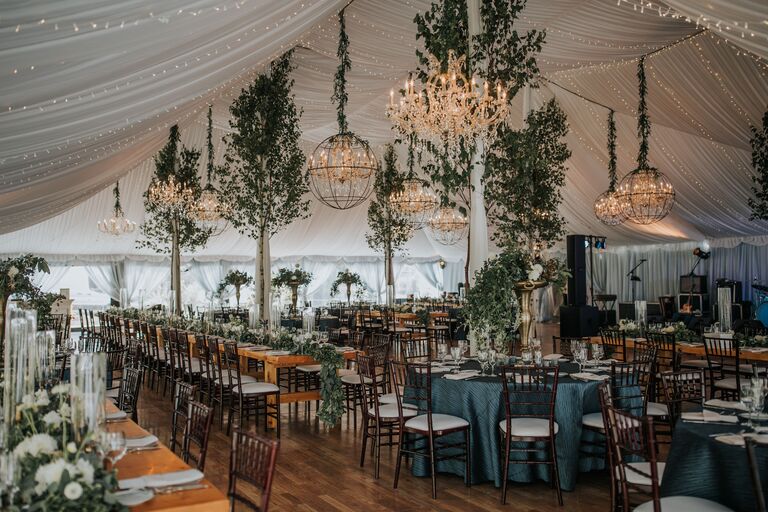 Tented reception with chandeliers and tree decorations