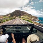 People in a jeep driving on the road.