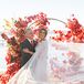 Bride With Windswept Tulle Cape With Groom in Classic Suit an Red Leaf Arch