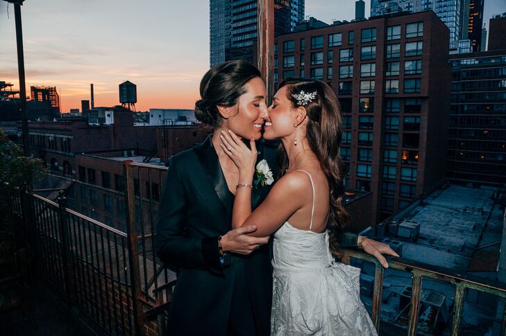 Bride With Down Hairstyle Kissing Her Bride in Black Blazer, Updo at Sunset in NYC, Skyline Backdrop