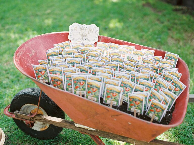 wedding favor display with flower seed packets in vintage red wheelbarrow