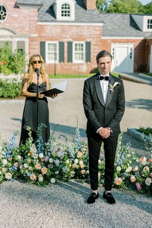 Officiant in Black Gown and Groom in Black Tux Waiting for Bride at Outdoor Altar, Gravel, Pastel Flowers