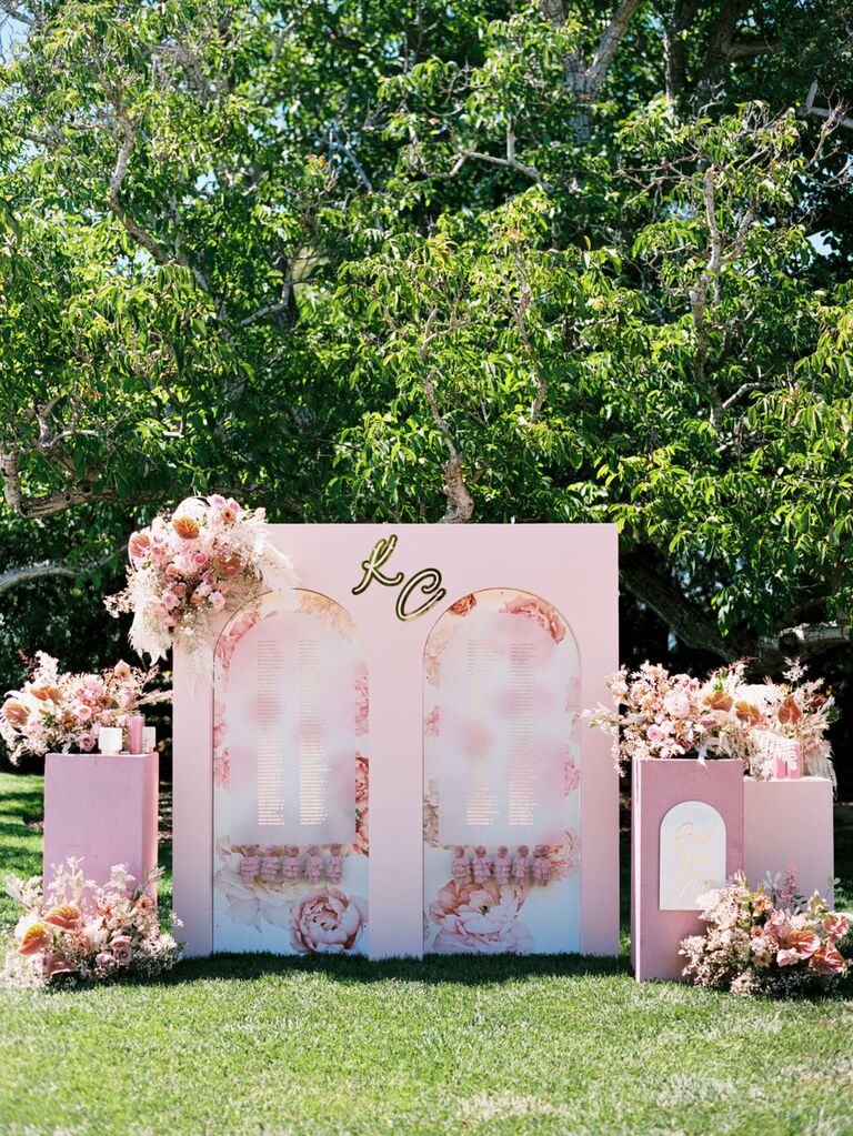 pink-and-gold seating chart backdrop sign