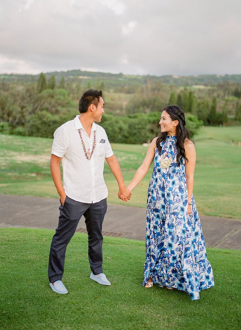 Couple holding hands on hill in Hawaii