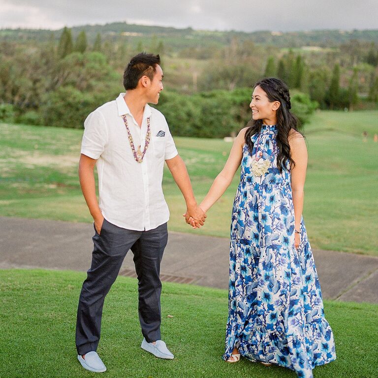 Couple holding hands on hill in Hawaii