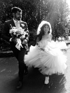 Bride and Groom Running Through Field