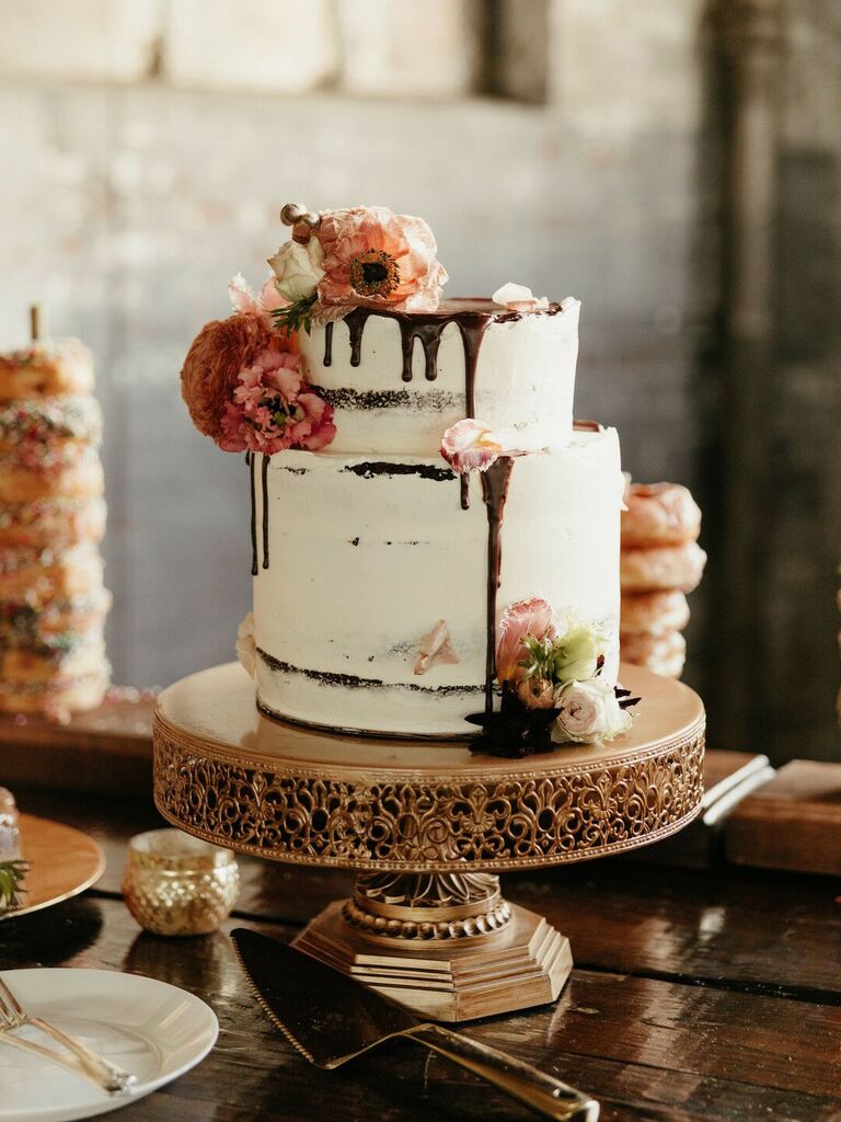 two tier buttercream wedding cake with chocolate drip icing and orange flowers