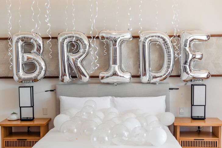 Large Silver Balloons on Hotel Room Wall Spelling "BRIDE," Getting Ready Space Before Destination Wedding