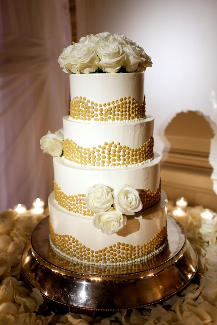 Chloe and David modeled their white wedding cake with gold-dot details and fresh white roses after their invitation design. The gold details channeled the glam of their reception at Rosewood Crescent Hotel in Dallas, Texas.