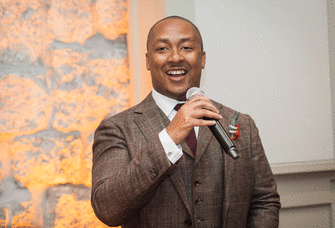Best man smiling and holding microphone.