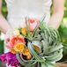 Kelly held a bold, textural bouquet of king protea, air plants, roses and dahlias.