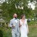 Groom in Light Gray Suit and Blue Bow Tie With Bride in Fitted Gown Carrying Cocktails