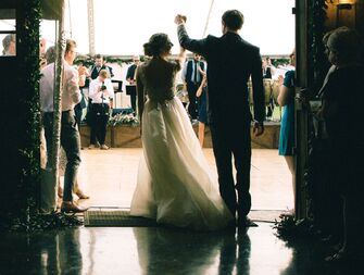Bride and groom walking into reception