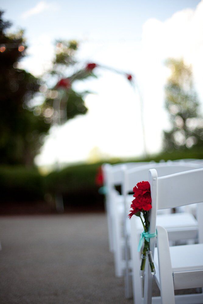 The ceremony aisles were marked with vibrant red carnations tied in bright light blue ribbons.