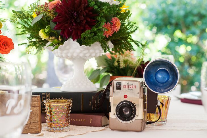 The bride collected vintage books, globes and cameras at flea markets and thrift shops to use as centerpiece vignettes.