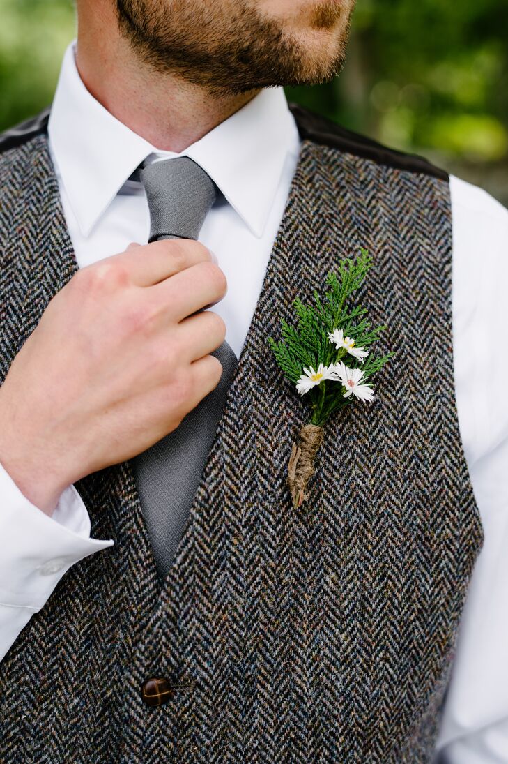 Justin accentuated his tweed vest with a rustic boutonniere made from dainty daisies and local greenery.