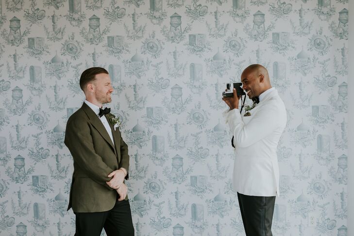 Groom in White Tuxedo Jacket Takes Photo of Groom in Green Suit Jacket