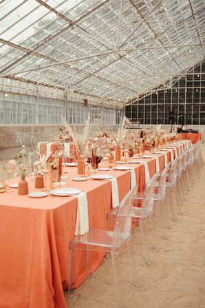 Long Reception Table with Coral Linens and Ghost Chairs