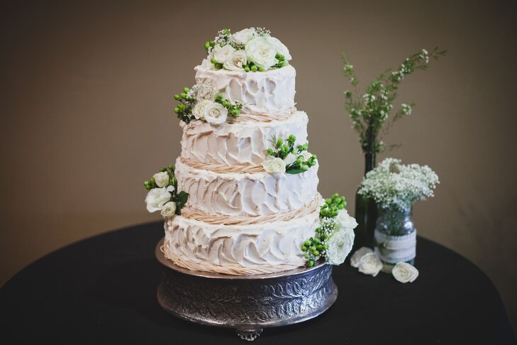 Kira and Kyle enjoyed a four-tier wedding blush buttercream wedding cake wrapped in twine and decorates with roses, baby’s breath and hypericum berries.