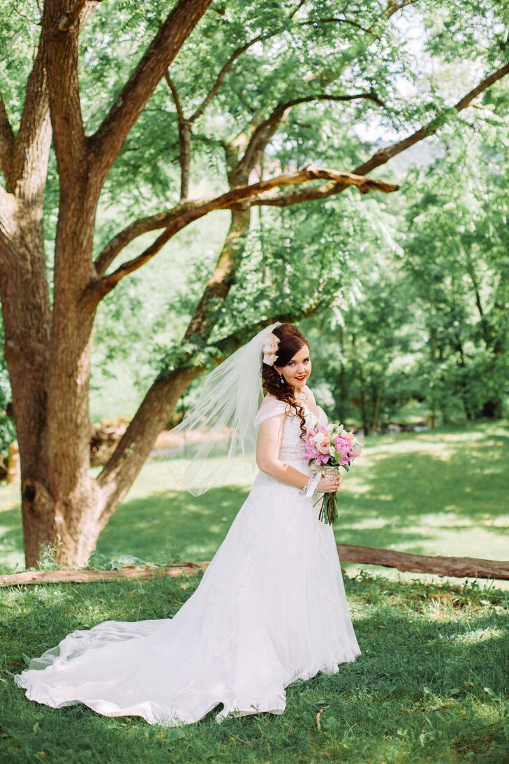 Angie wore an A-line Casablanca wedding dress with cap sleeves and lace overlay. It featured beading throughout the bodice and a long, dramatic train.