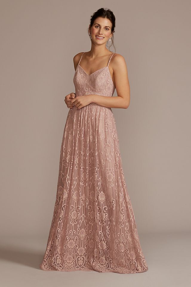 Model wears a spaghetti strap lace dress in a beautiful blush pink color. 