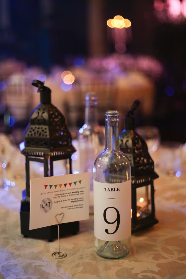 Instead of using flowers throughout the reception decor, the bride chose black candleholders and clear glass bottles as the focal point for each table.