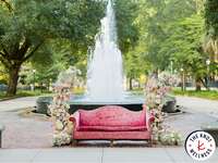 Couch surrounded by flowers in front of fountain