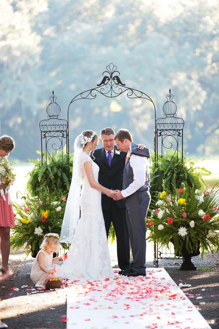 A wrought iron gate surrounded by green ferns served as a backdrop for the outdoor ceremony.