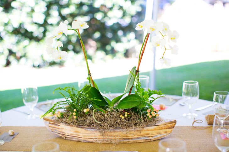 Some tables were decorated with whitewashed boats filled with phalaenopsis orchids, button ferns, autumn ferns and burlap accents, while other tables had vintage lanterns, beachwood, baby’s breath and candles surrounded by flowers.